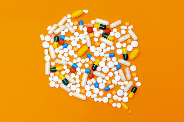 Variety of medications and tablets for hookworm treatment for pets on an orange background